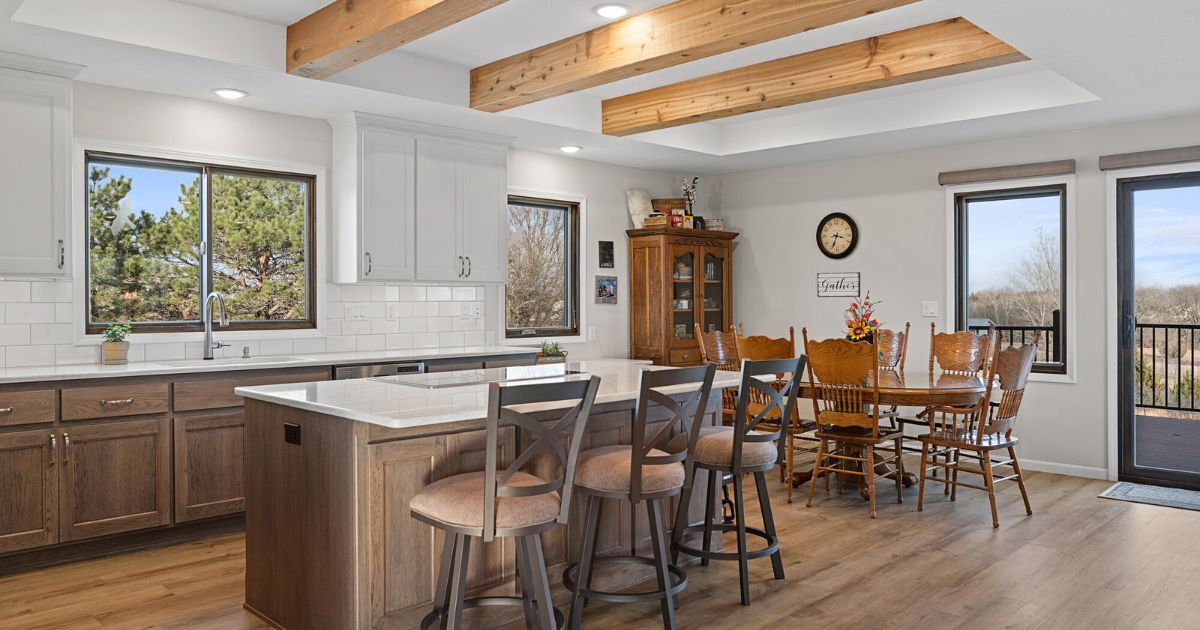 Open-concept kitchen remodel with a seating island, dining area, white countertops, and two-tone cabinetry by Fox Home Innovations in Manhattan, KS