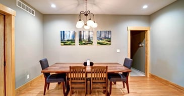Remodeled dining room in Manhattan, KS with hardwood floors, wood trim, and a chandelier above the dining table by Fox Home Innovations