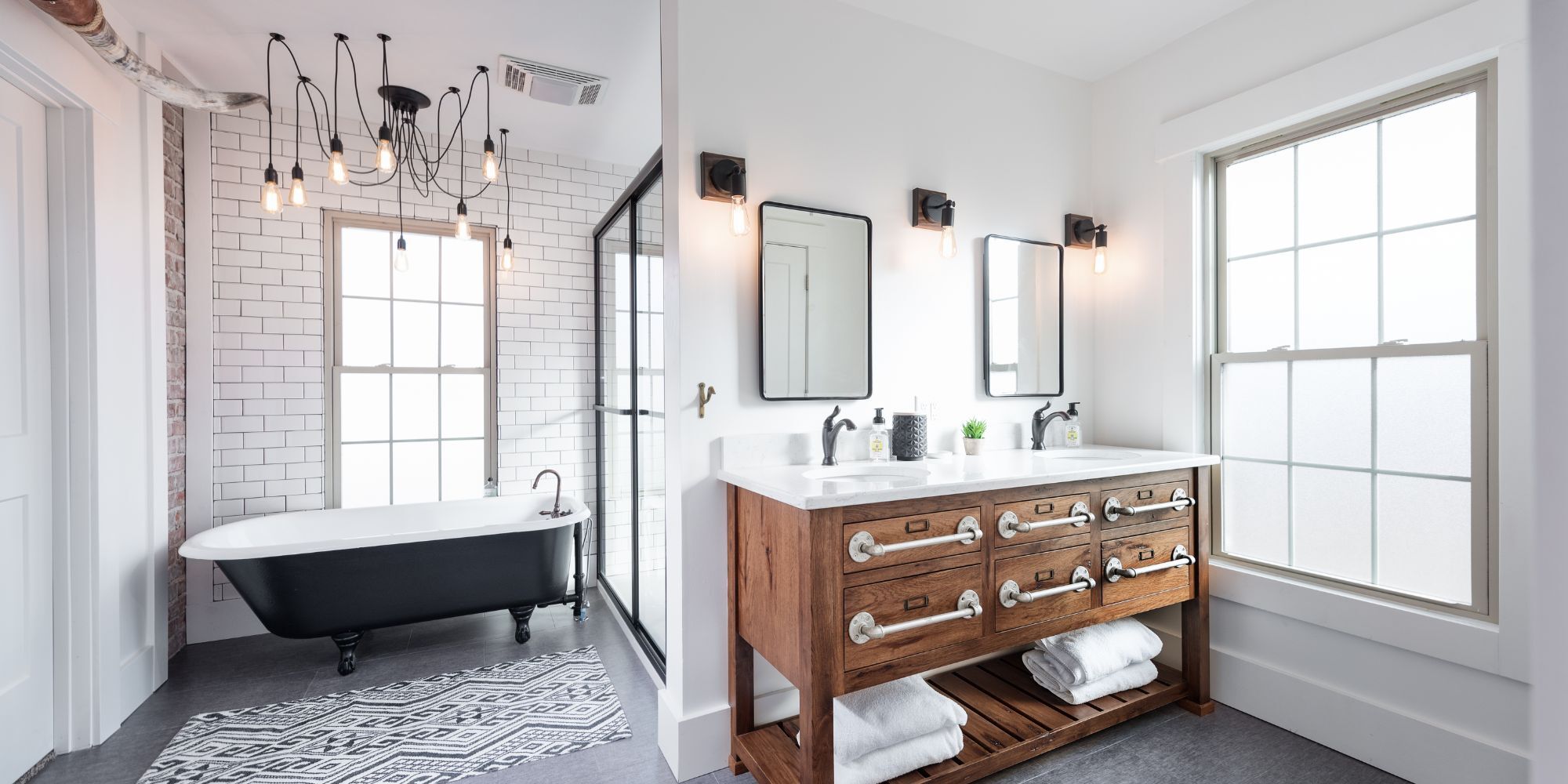 Bright bathroom remodel with a custom wood vanity, standalone tub, and large glass shower by Fox Home Innovations in Manhattan, KS