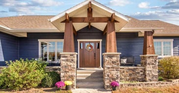 View of the front entrance of a remodeled home with a wooden door in Manhattan, KS by Fox Home Innovations