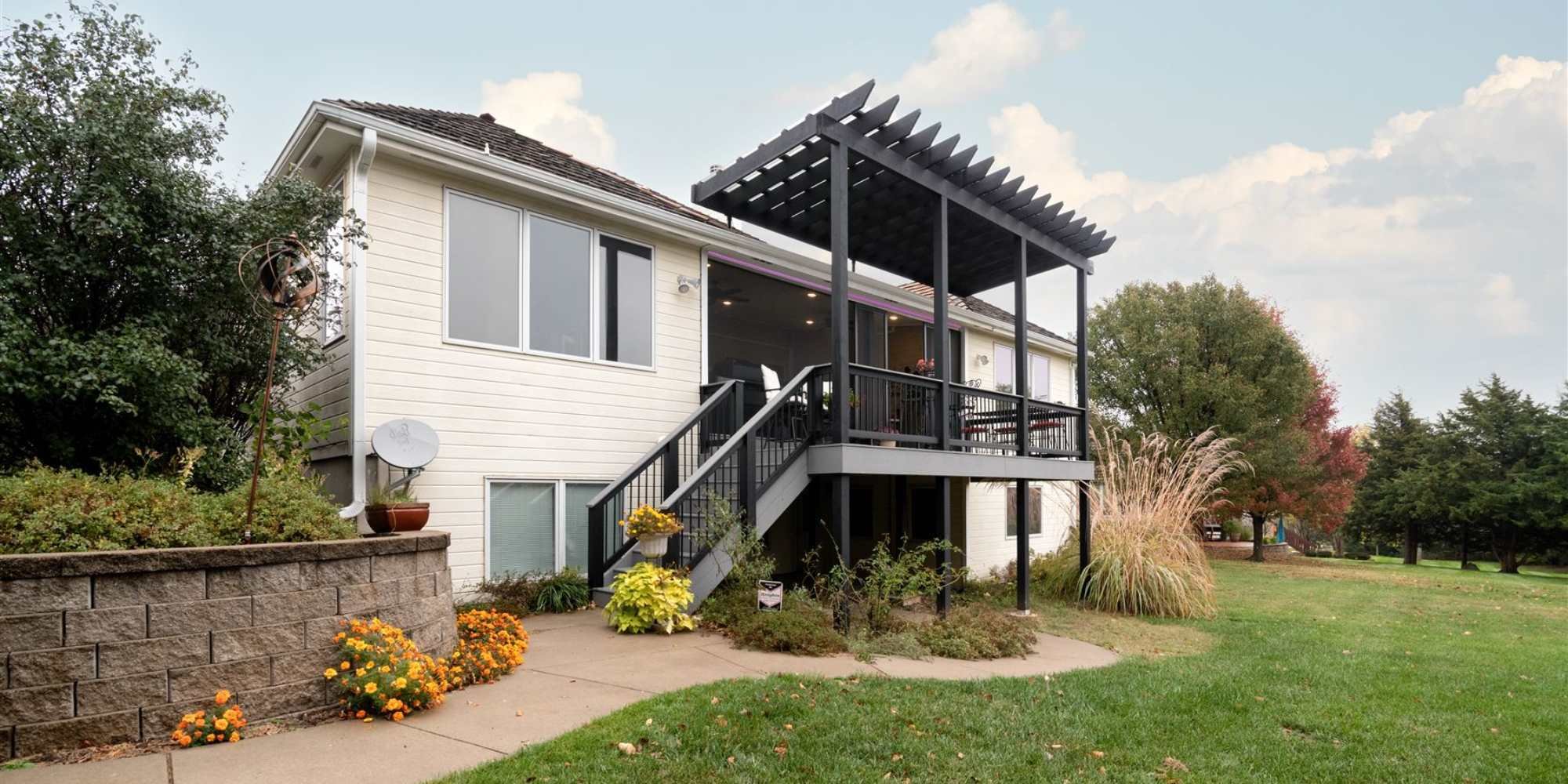 A remodeled home in Manhattan, KS with a pergola and new siding by Fox Home Innovations