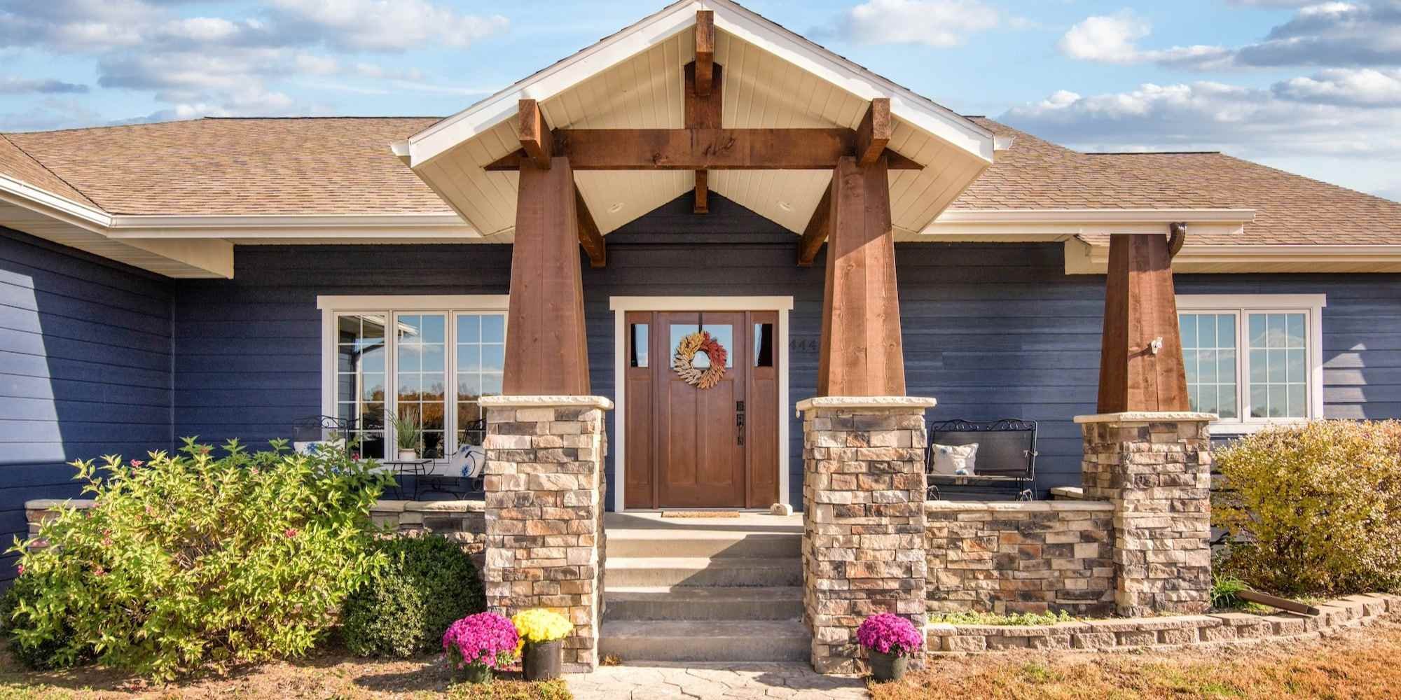 View of the front entrance of a remodeled home with a wooden door in Manhattan, KS by Fox Home Innovations