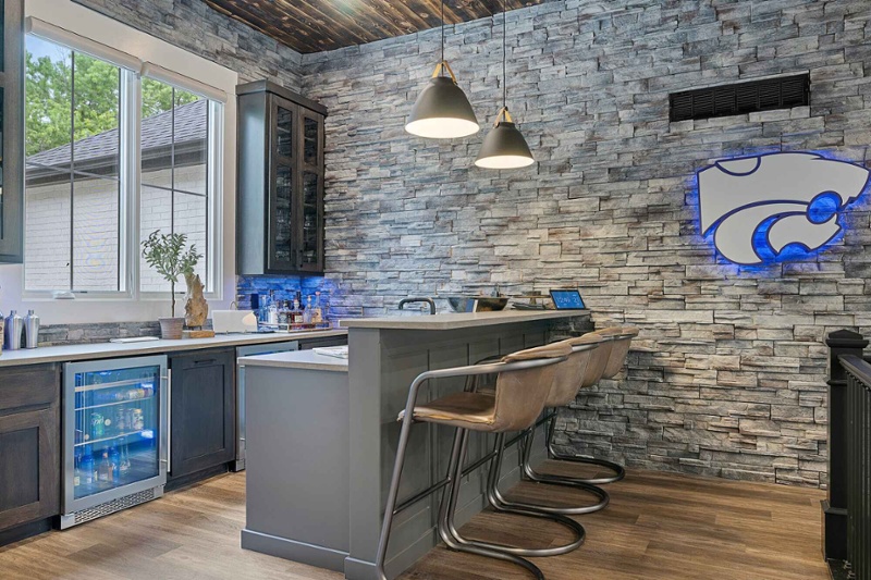 Home bar with wine fridge and stone accent wall