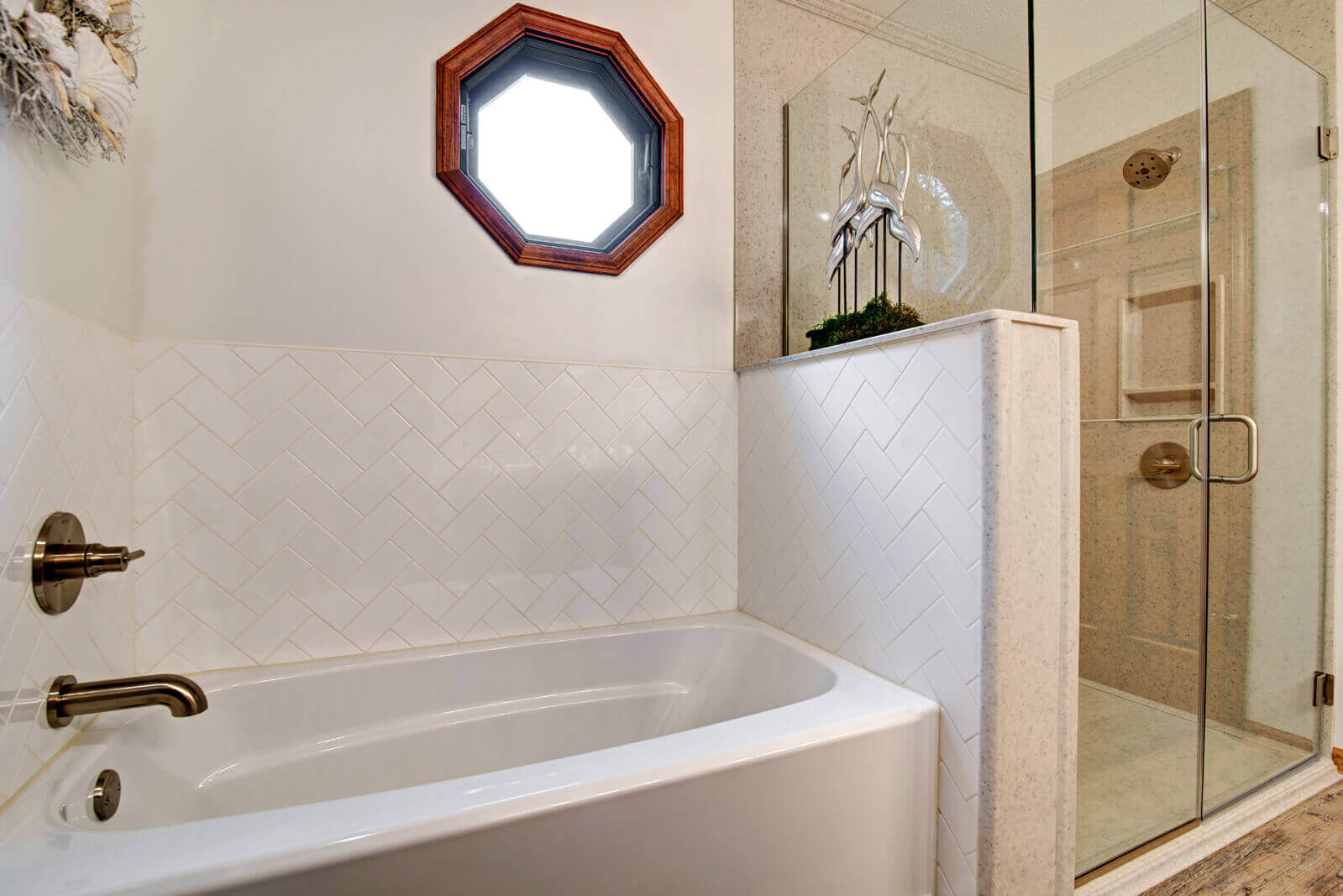 A remodeled bathroom in Manhattan, KS with a glass shower and a bathtub with new caulk and tile by Fox Home Innovations