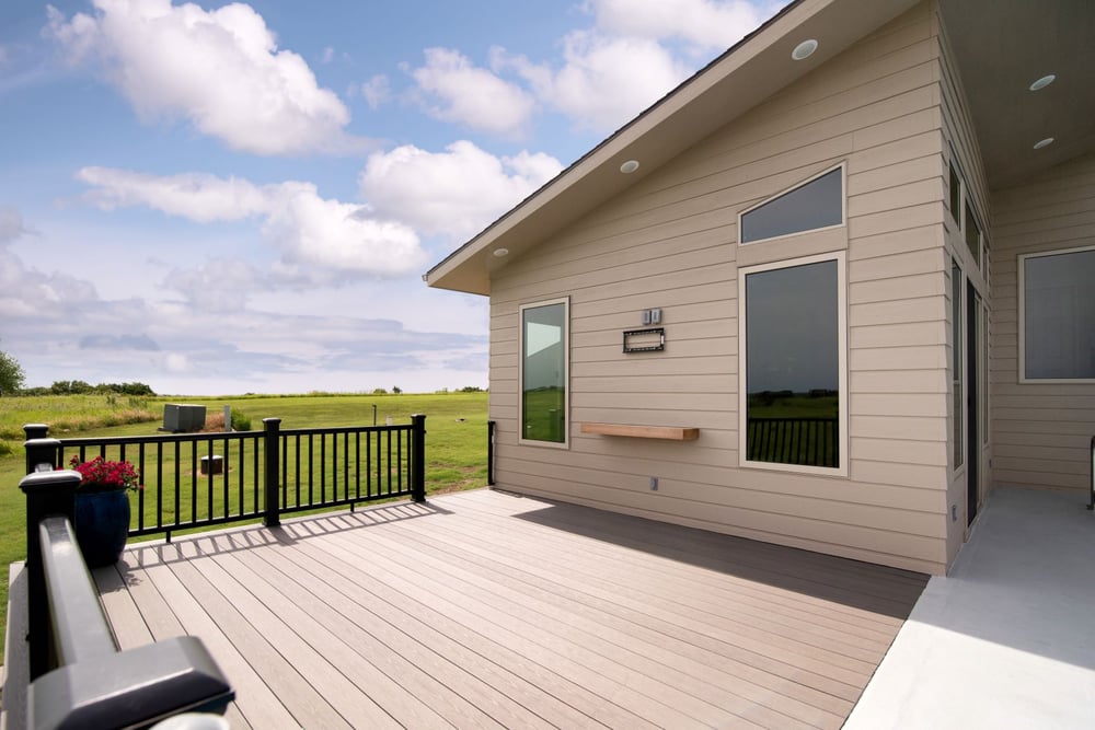 A large, open deck with a metal railing by Fox Home Innovations