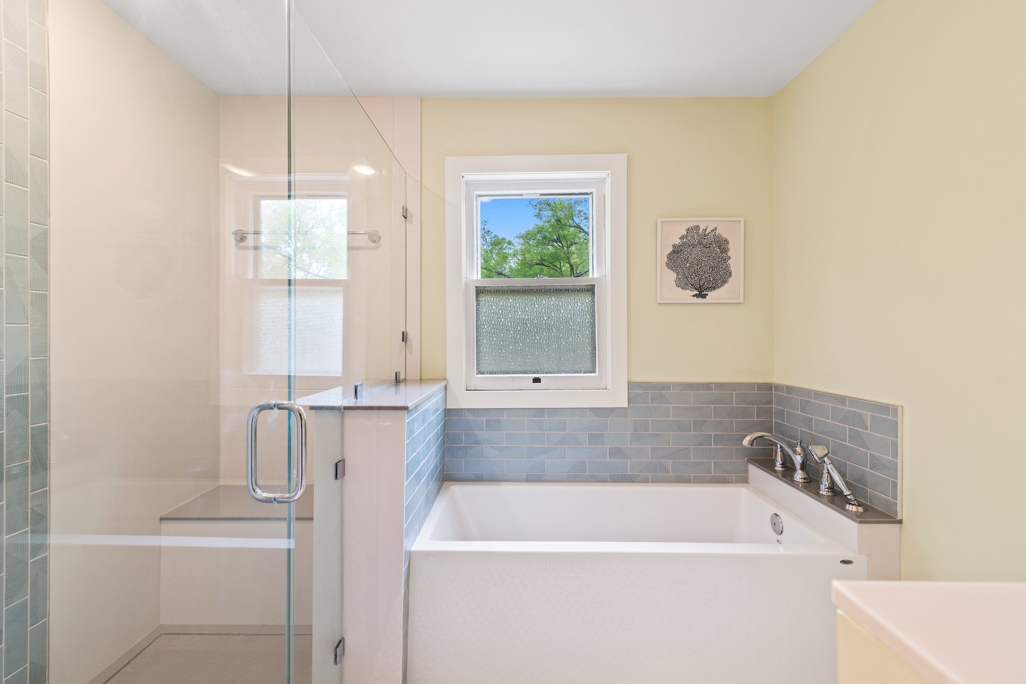 Bathroom remodel featuring a large glass shower, a soaking tub, and blue tile walls in Manhattan, KS by Fox Home Innovations